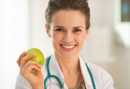 Portrait of smiling medical doctor woman with apple